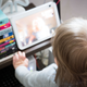 A photo of a kid staring at an Amazon Echo device with her Grammy on the screen